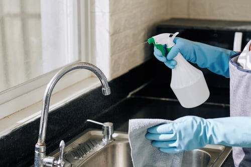 Detailed first-time cleaning of a kitchen sink and countertop