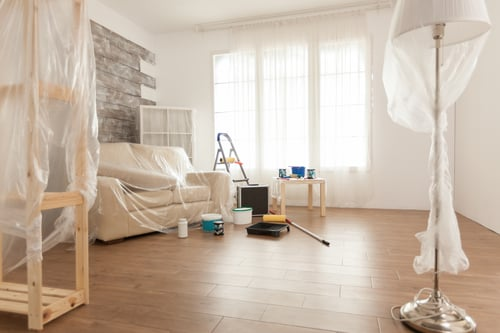 Renovated living room with protective coverings and cleanup equipment