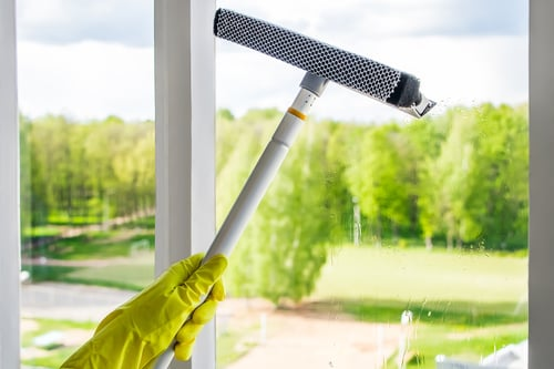 Cleaning a home window with a squeegee
